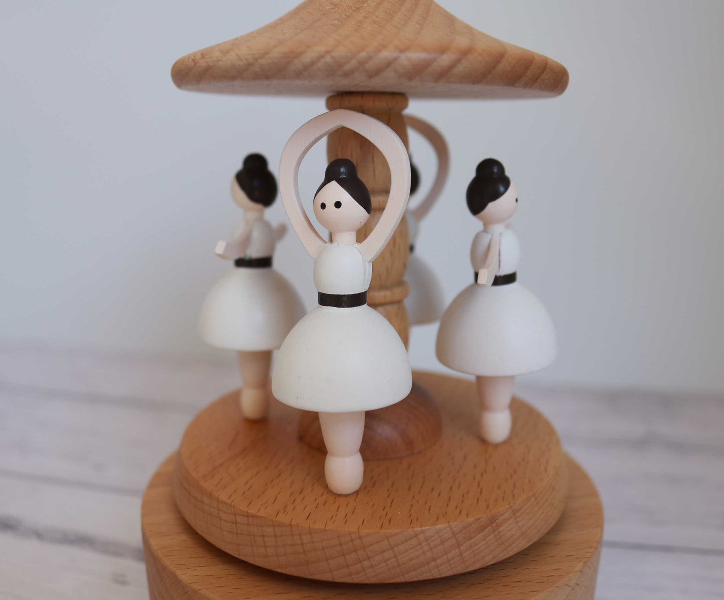 Wooden music box with ballerina figurines on a white background