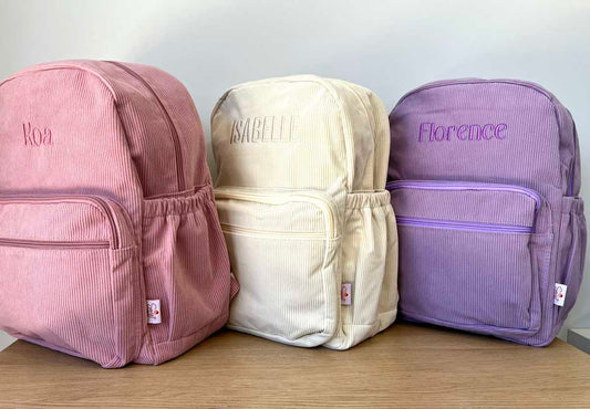 Personalised Corduroy Backpacks with Custom Embroidered Name, shown in Pink, Cream and Purple Corduroy