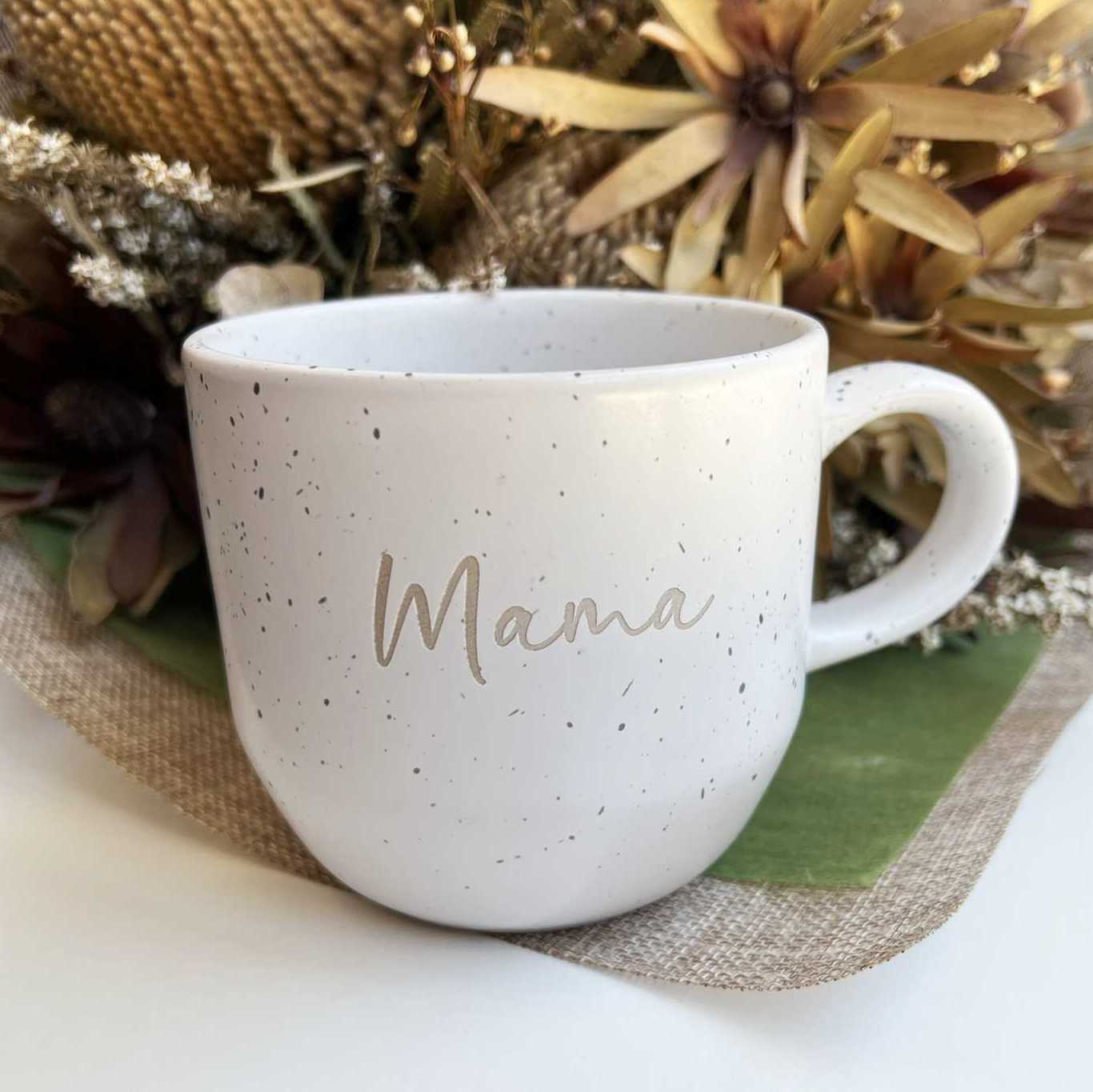 Close-up of engraved word 'mama' on ceramic mug