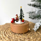 Wooden Christmas music box with Santa Claus and tree on a woven surface