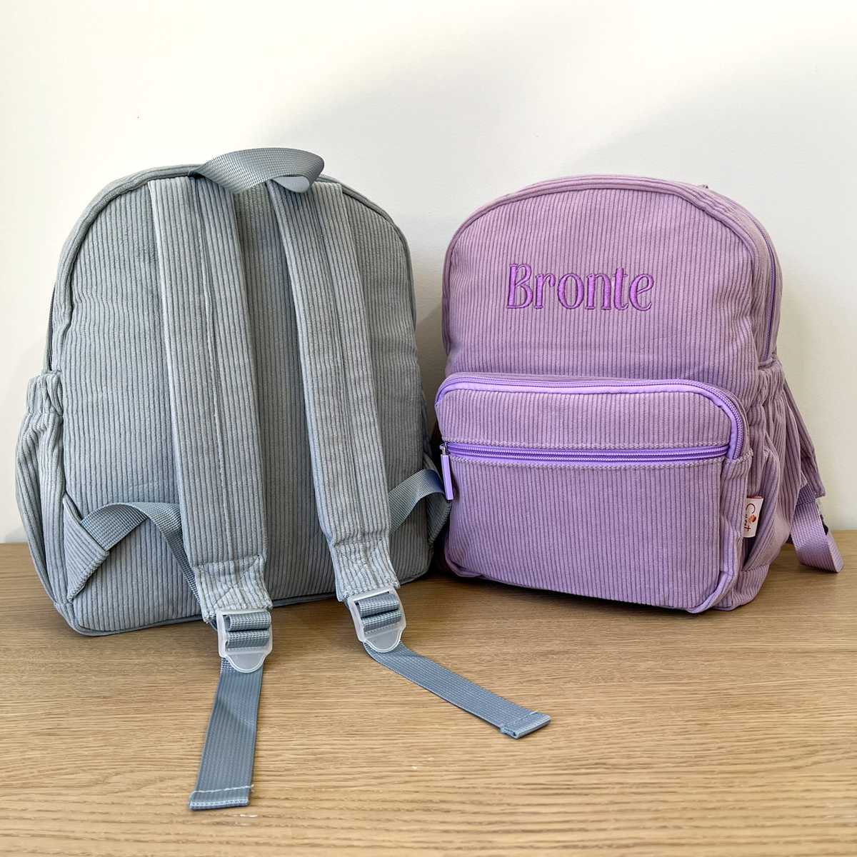Personalised Kids School Bag with custom name embroidery, shown in blue and purple