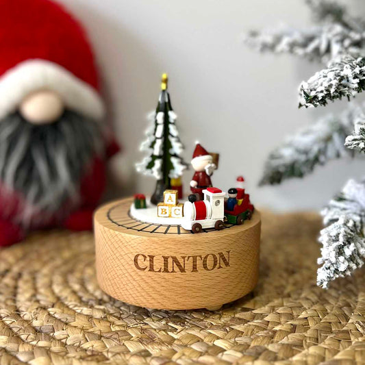 Custom laser engraved round wooden musical christmas train carousel with name Clinton in bold font