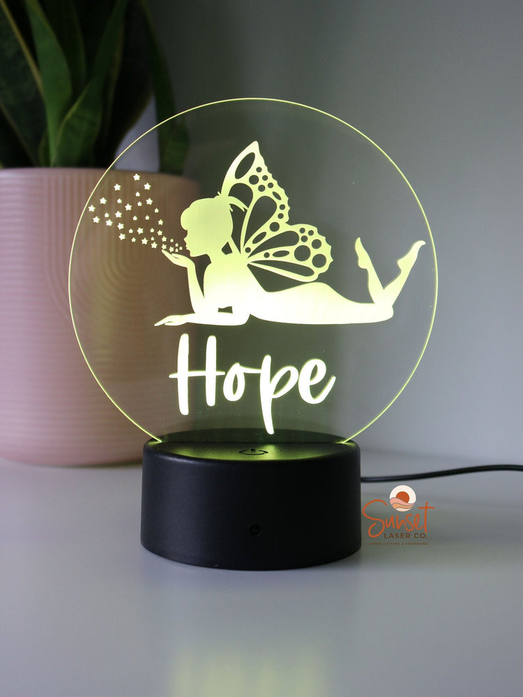 Personalised Night Light with a fairy design sitting on a bedside table 